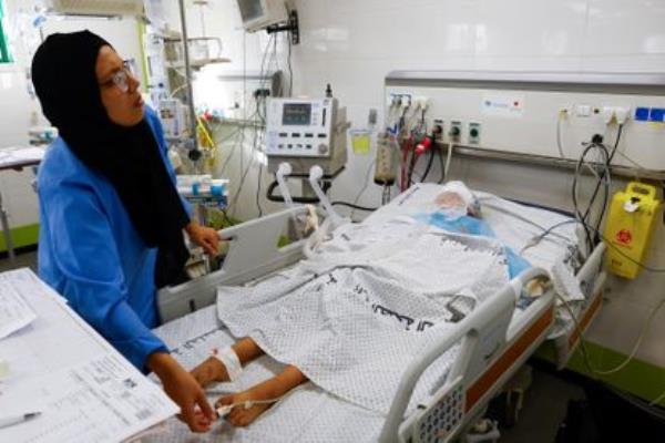 A health worker attends to a Palestinian teenager admitted to the Intensive Care Unit of the Nasser hospital in Gaza on Thursday. Doctors at the hospital have complained that they can o<em></em>nly treat critical cases due to fuel shortages.