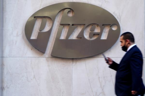 A person walks past the Pfizer Headquarters building